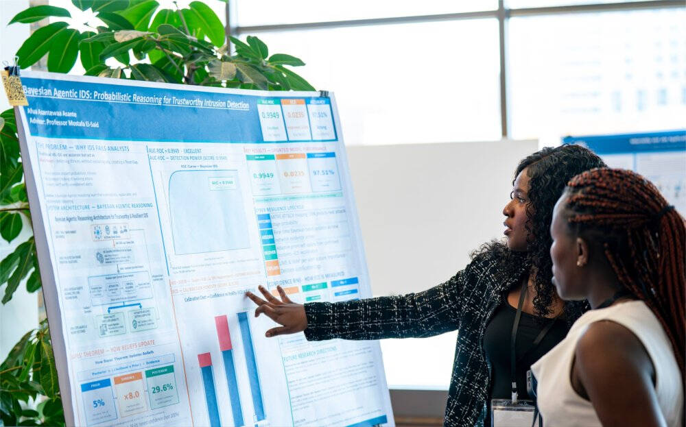 Cybersecurity majors Afua Asante, left, talks with Margaret Kihumba, as part of the College of Computing Innovation Day: Computing + X at the Eberhard Center on April 24. Asante worked on the project "Bayesian Agentic IDS: Probabilistic Reasoning for Trus
